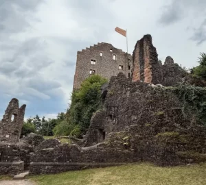 Frontansicht einer Burgruine umgeben von Gras.