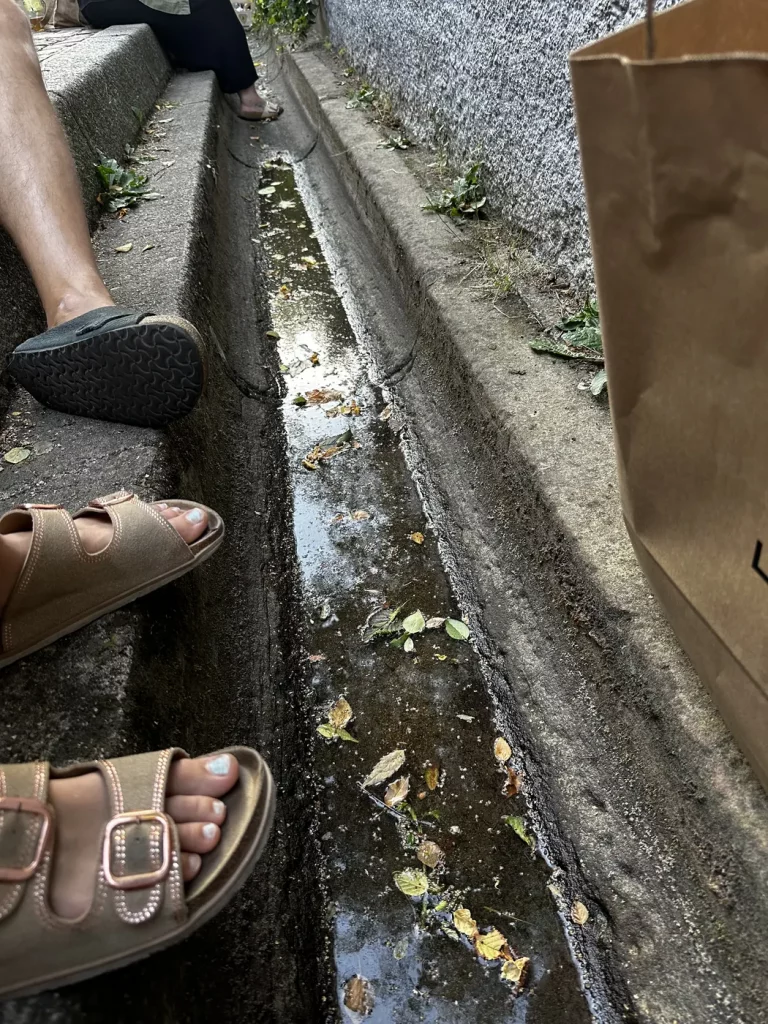 Füße im Freiburger Bächle während eines Picknicks in der Altstadt