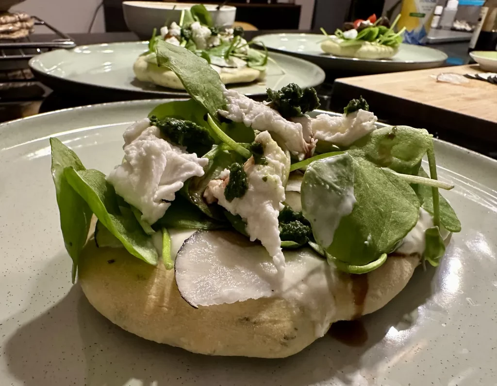 Fertig belegtes Bärlauch Fladenbrot aus dem Schwarzwald mit Salat und cremigem Belag angerichtet