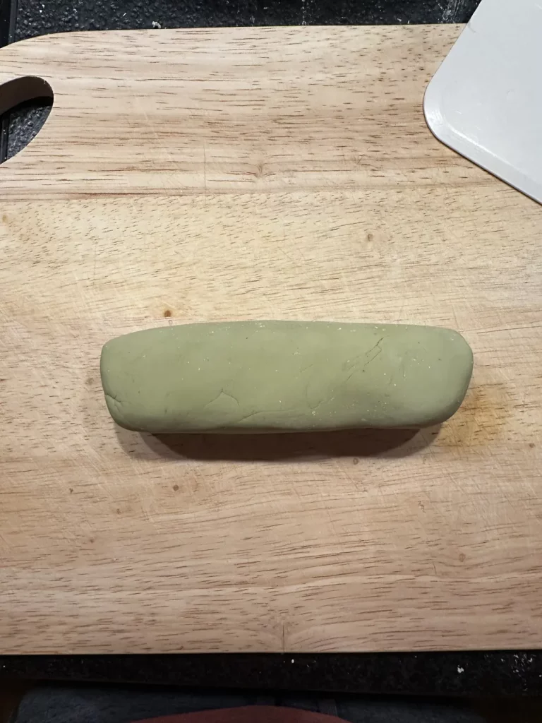Grüner Tteok Teig wird zu einer glatten Rolle geformt