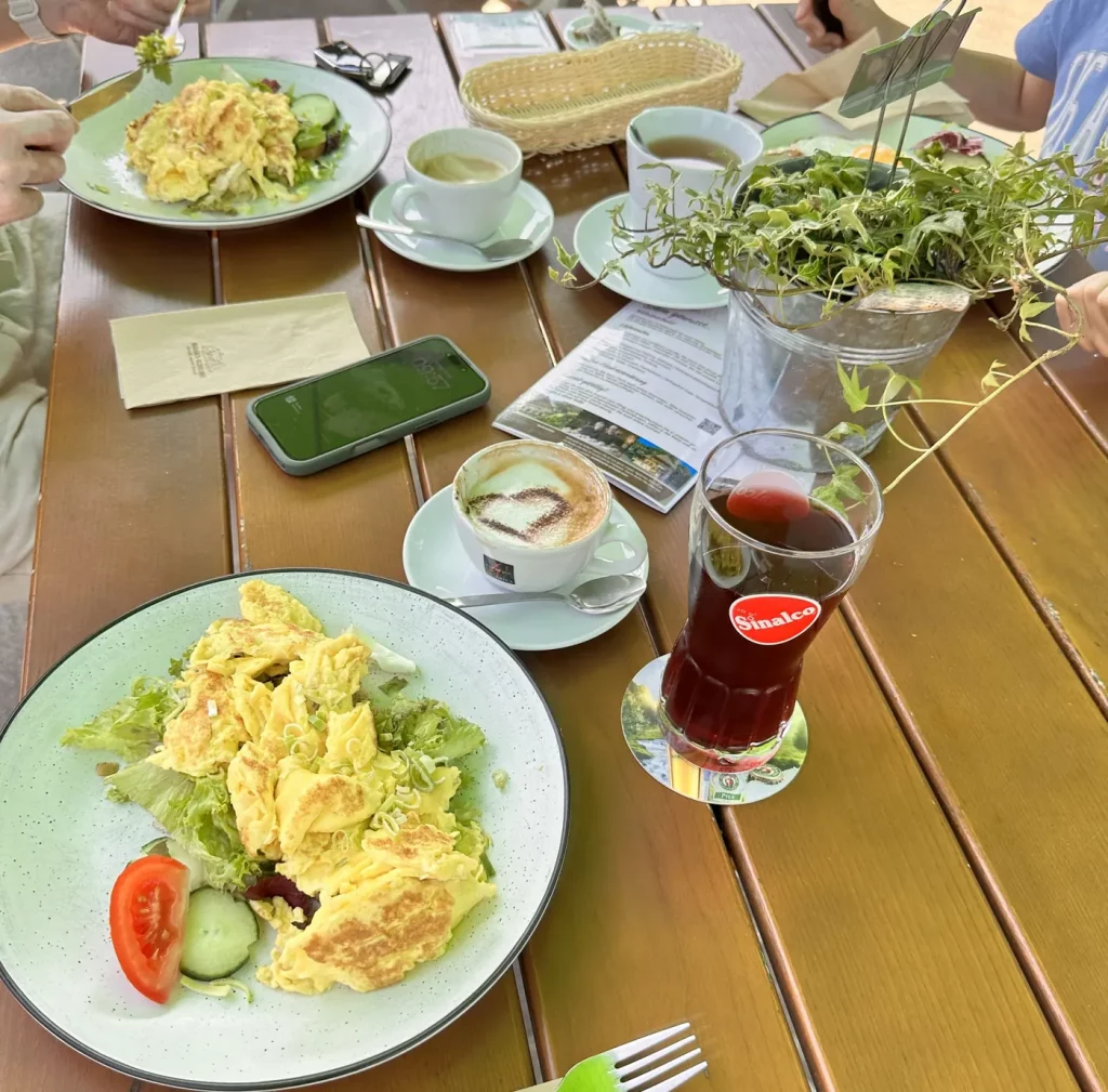 Frühstückstisch gedeckt mit Rührei, Kaffee und Saft