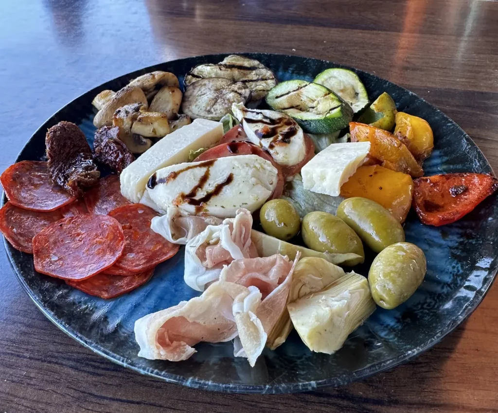 Italienische Antipasti-Platte mit gegrilltem Gemüse, Salami, Schinken und Käse in der Pizzeria La Famiglia in Offenburg