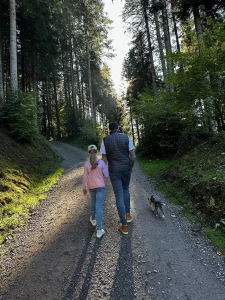 Familie mit Hund auf einem Waldweg im Gegenlicht nahe dem Sägersweiher im Schwarzwald