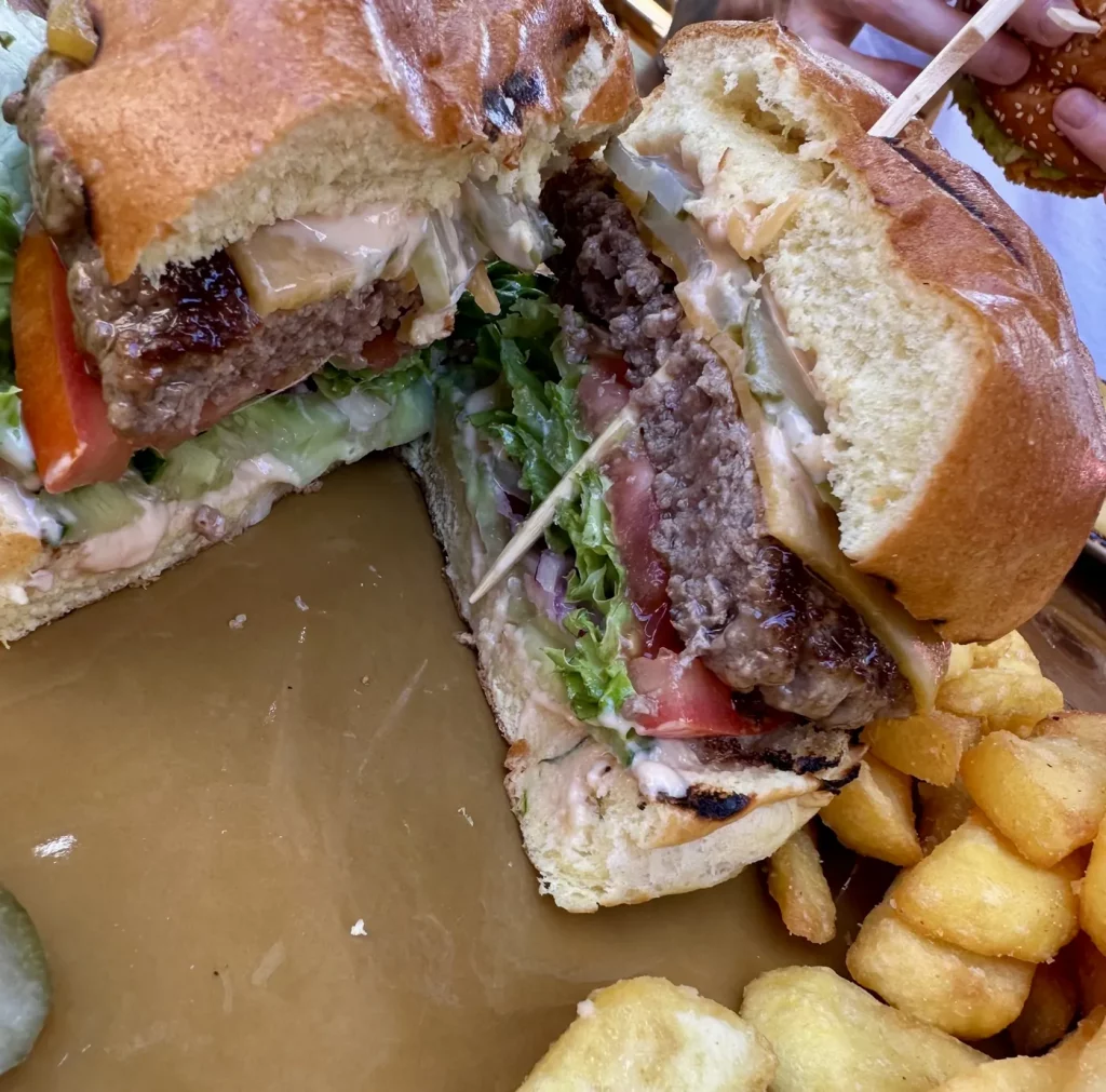 Aufgeschnittener Burger mit saftigem Patty, Salat und Sauce im Wild Bills Saloon in Lahr