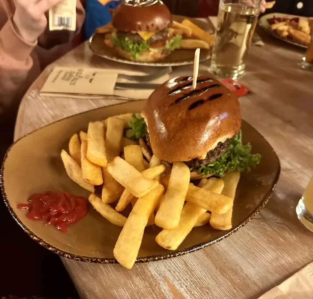 Üppiger Burger mit glänzendem Brioche-Bun und Pommes im Wild Bills Saloon in Lahr